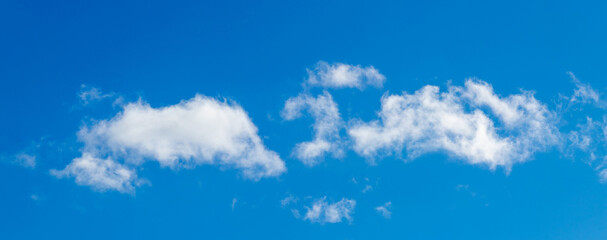 White clouds on a blue sky in bright colors, panorama