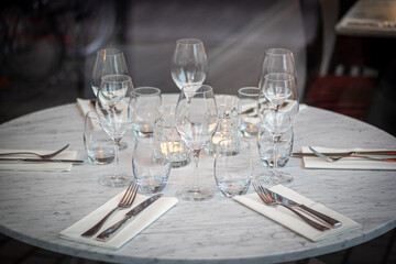 Empty round restaurant table with wine glasses and candles 