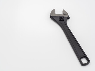Black open adjustable wrench on a light background