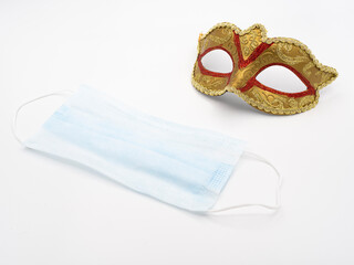 Surgical blue mask and classic carnival mask on white background