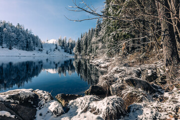 Taubensee im Chiemgau im Winter mit Schnee und Sonne bei blauem Himmel