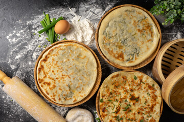 Three types of classic unleavened wheat flatbread with herbs and cheese made from flour, eggs, onions and water. An assortment of freshly baked bakery products.