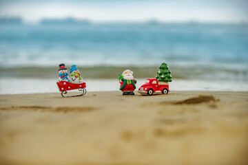 Obraz premium Christmas background. Toy Santa and snowman on summer beach, concept for travel in hot countries.