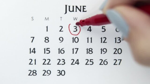 Female hand circle day in calendar date with a red marker. Business Basics Wall Calendar Planner and Organizer. June 3th