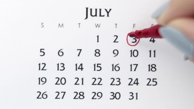 Female hand circle day in calendar date with a red marker. Business Basics Wall Calendar Planner and Organizer. July 3th