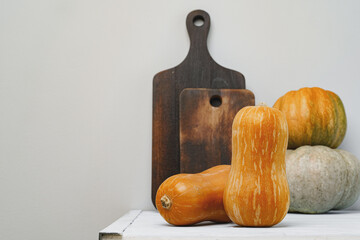 Pumpkins on kitchen table against grey wall