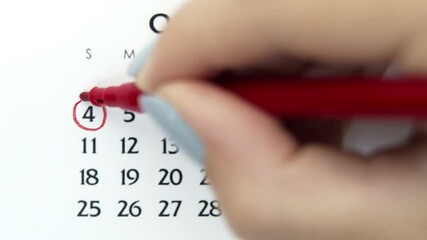 Female hand circle day in calendar date with a red marker. Business Basics Wall Calendar Planner and Organizer. October 4th