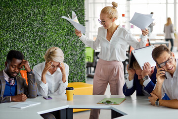 furious female director dissatisfied with work, she yells at emplyees holding papers documents in...
