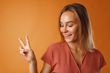 Young happy smiling woman showing victory sign.