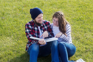 Students read a book in the Park on the lawn.