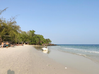 Boat and tourists on the white sand beach. Sea and trees. 4K Beach. Koh Rong island. Cambodia. South-East Asia