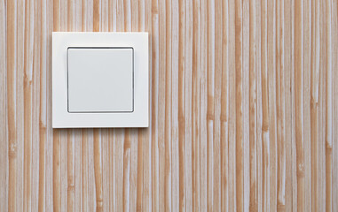 White electric light switch on the background of plastic wall panels. Home electricity.