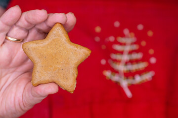 Star-shaped gingerbread cookie on red Christmas background