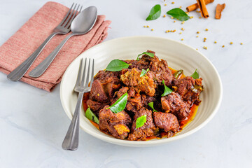 Indian Lamb Masala/Mutton Masala Garnished with Onion, Curry Leaves and Hot Chili Peppers Close Up Photo