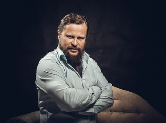 Confident solid bearded man dressed in shirt studio portrait