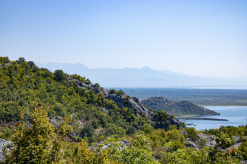 A beautiful view of the Skadar (Skoderskoe) lake among the mountains. This section of the lake is overgrown with tall grass. Montenegro. 