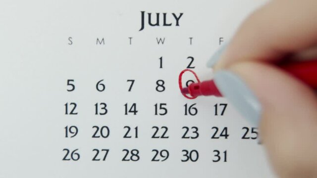 Female hand circle day in calendar date with a red marker. Business Basics Wall Calendar Planner and Organizer. July 9th