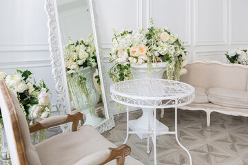 Luxury white interior of living spacious room with elegant chic furniture and high windows.