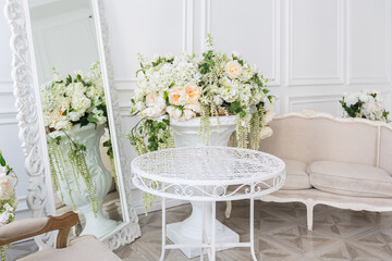 Luxury white interior of living spacious room with elegant chic furniture and high windows.