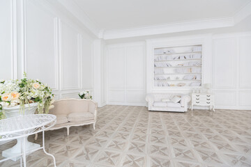 Luxury white interior of living spacious room with elegant chic furniture and high windows.