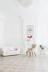 Fototapeta na wymiar Luxury white interior of living spacious room with elegant chic furniture and high windows.