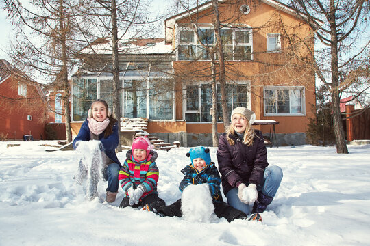 family playing with snow in the winter outdoors