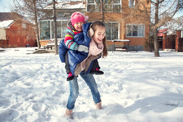children playing in the yard of his house in the winter outdoors