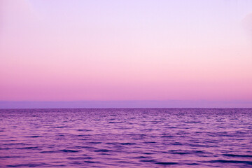clear sunset sky, sea and skyline in pink tones
