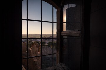 View of the medieval village of Belmonte through a window of the castle at sunset, Cuenca, Spain