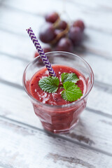 Fresh smoothie in a glass. Bright wooden background. Close up.	