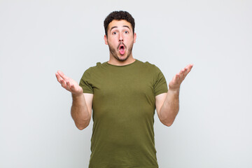 young man feeling extremely shocked and surprised, anxious and panicking, with a stressed and...