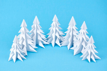 Obraz premium White paper origami christmas trees on blue background