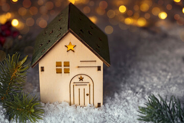 wooden christmas house on the snow, background with bokeh