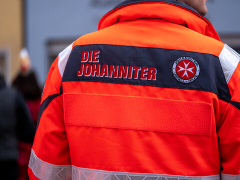 Berlin, Germany - February 09. 2020: Berlin, Germany - February 09, 2020: Johanniter logo, a German ambulance company, on the backside of an orange uniform
