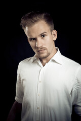 Naklejka premium Young man dressed in white shirt studio portrait