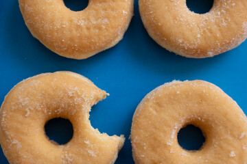 Bitten donut on blue background