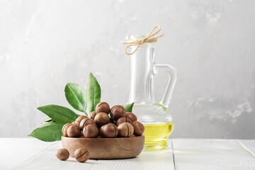 Macadamia oil. Bowl of macadamia nuts on a white wooden table.