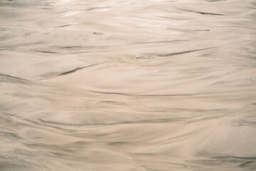 Sand beach nature texture in summer sun as background. Sand pattern of a beach.