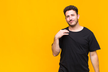 young man looking arrogant, successful, positive and proud, pointing to self