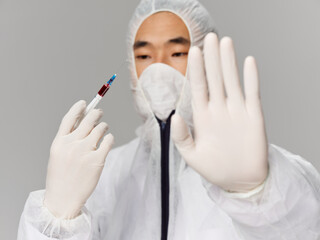 A man of Asian appearance holds a hand in front of him vaccination research laboratory