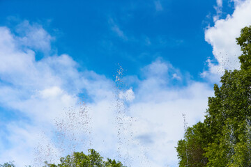 Splashes of fountain water in a sunny day. blue sky background