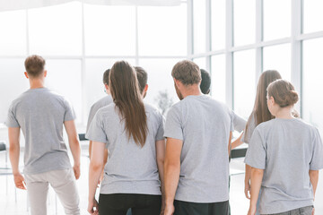 rear view. a group of young people standing in a bright room