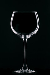 Large glass goblet with beautiful highlights on a black background. Wine glass. Isolate.