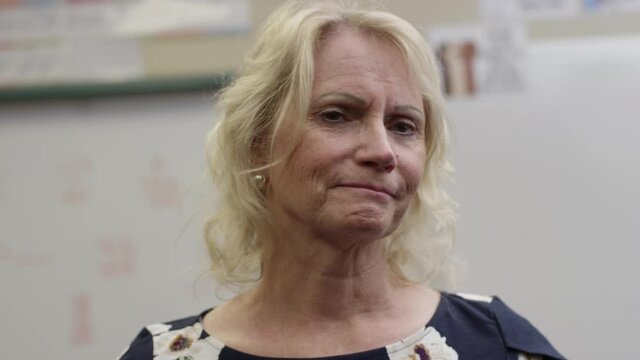 Older Caring Female Teacher Looks At Student With Worried Expression