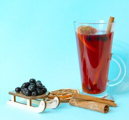 herbal tea with chokeberry, cinnamon and dried oranges on blue background, aronia berry is effective in combating COVID-19 virus