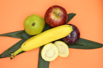 Fruta surtida puesta sobre fondo naranja