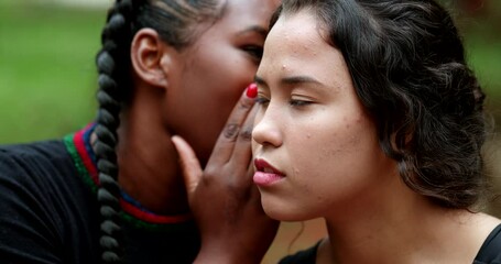 Woman telling secret to friend ear. Friends together sharing gossip