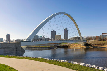Looking at the Des Moines Iowa skyline through the Woman of Achievement Bridge over the Des Moines River during daytime.