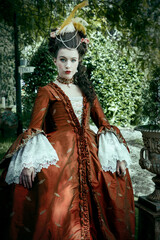 Obraz premium A Georgian woman wearing a silk robe a la Francaise and walking in a garden