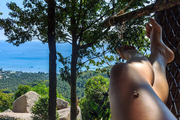 natural green island panoramic view, girls legs in hammock